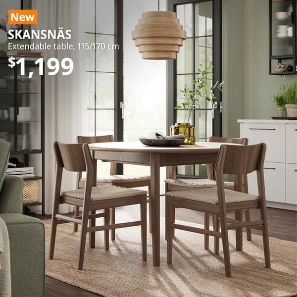 Brown beech veneer SKANSNÄS extendable table paired with four SKANSNÄS chair in brown beech is in the middle of the dining area next to the living area. An orange "NEW" label is on the top left of the image with white text that reads: SKANSNÄS, extendable table, 115 cm and can extend to 170 cm. $1,199