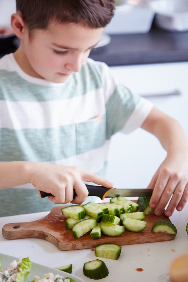 Bruno, le fils de Margo, l'aide à préparer des salades simples
