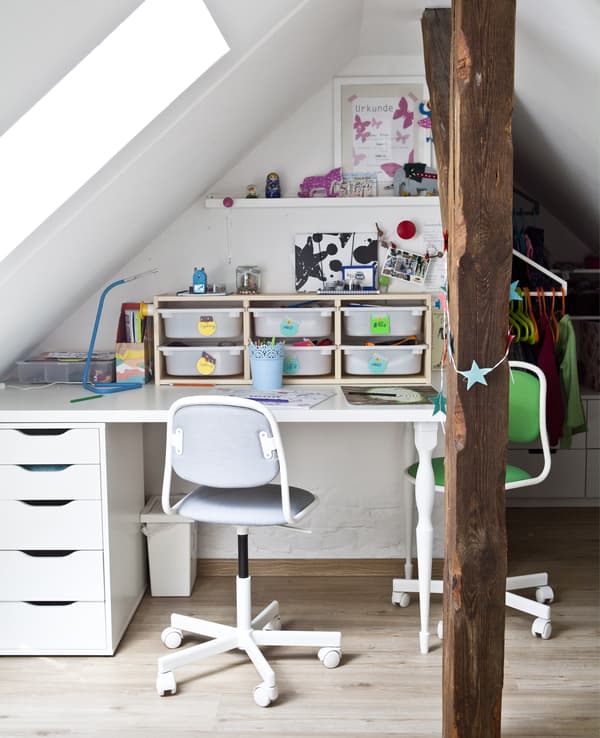 Bureau d’enfant avec boîtes de rangement et deux chaises.