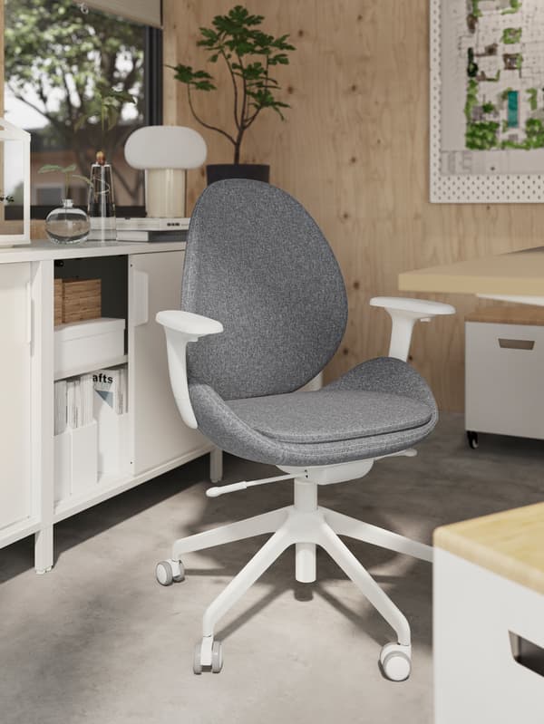 Bureau ensoleillé avec des murs en bois clair et une chaise de bureau HATTEFJÄLL gris moyen entourée de rangements.