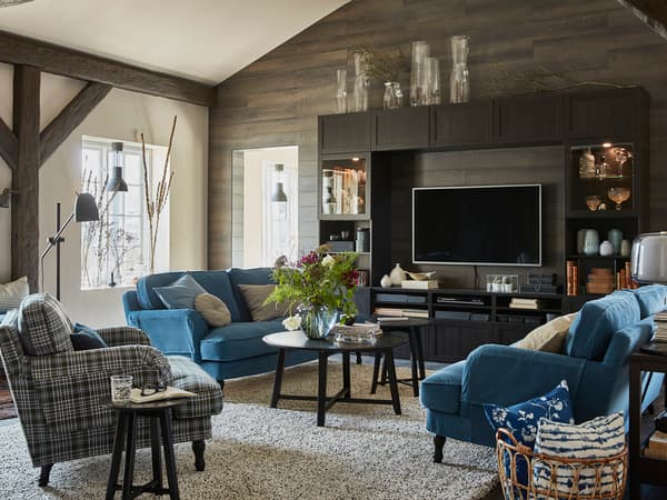 ブルーのソファとチェック柄チェアを組み合わせたナチュラルリビング。木梁と観葉植物が特徴。