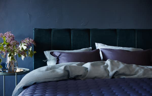 Cabecero tapizado fabricado con cortinas de terciopelo de algodón azul oscuro, relleno de espuma y una estructura de cama MALM.