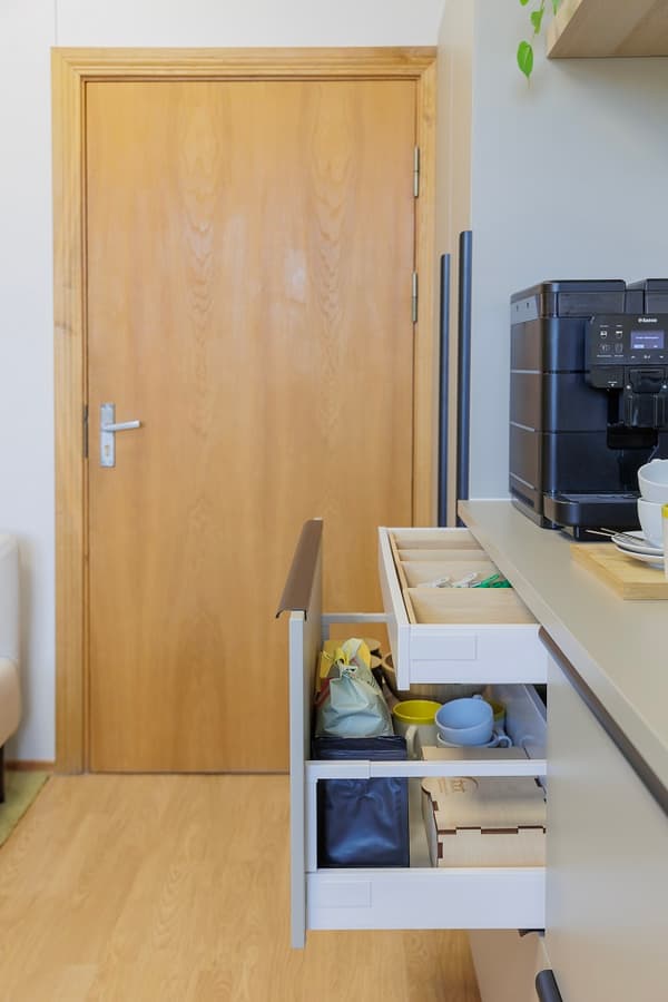 Cabinet drawer open with kitchen items and coffee supplies