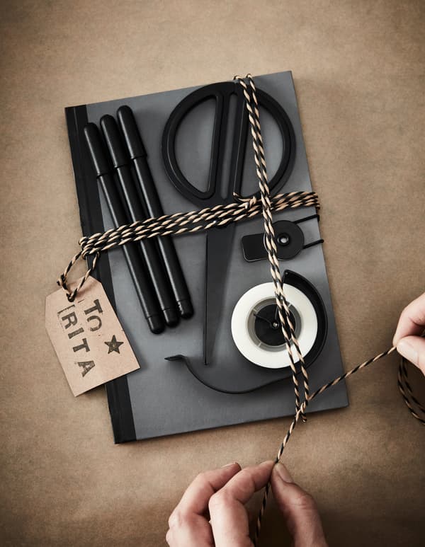 Cadeau créatif avec carnet, stylos, ciseaux et ruban adhésif.