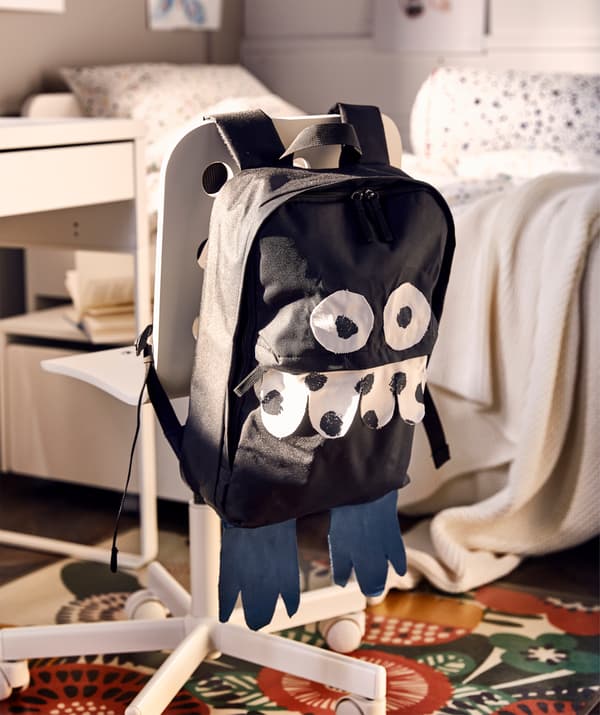 Cadeira xiratoria infantil cunha mochila que se volveu un simpático monstro grazas a unhas tiras de tea pegadas co ferro de pasar.