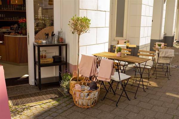 Café-Außenbereich mit Möbeln aus natürlichem Akazienholz und einem Arbeitstisch von IKEA
