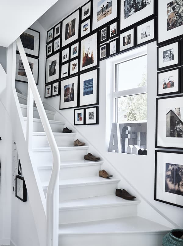Cage d’escalier décorée de cadres au mur.