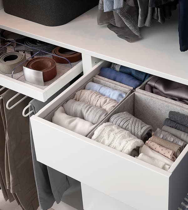 Caixas de almacenamento de feltro gris KOMPLEMENT, cheas de roupa en cores pasteis, dentro dun caixón branco.