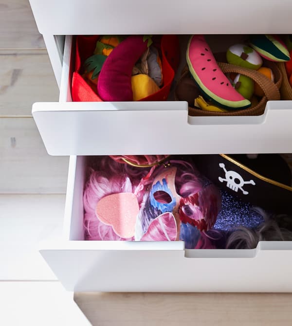 Cajonera del niño llena de peluches y gorros.