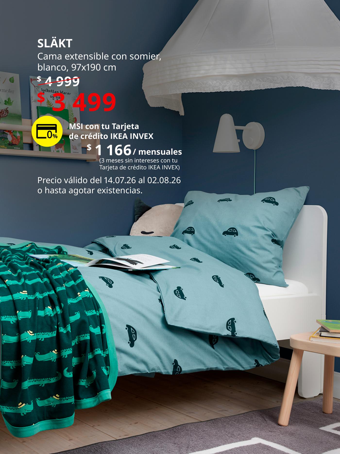 Cama infantil SLÄKT blanca en habitación infantil con ropa de cama estampada, lámpara de pared y mesita auxiliar.