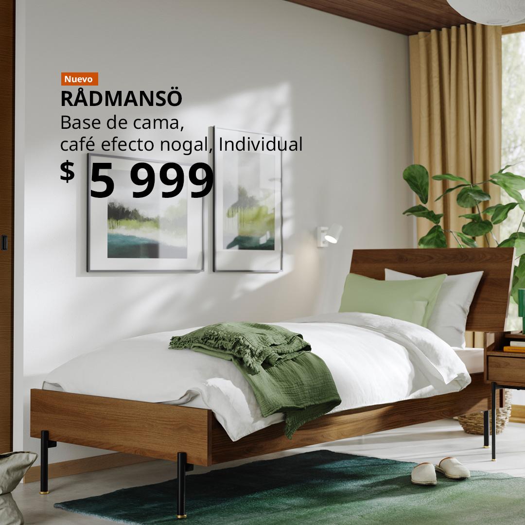 Cama RÅDMANSÖ individual color café efecto nogal con cabecera, vestida con ropa de cama blanca y verde, en un dormitorio luminoso.