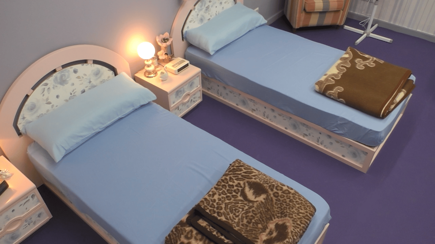 Camas con cabeceros de colores en un dormitorio antiguo