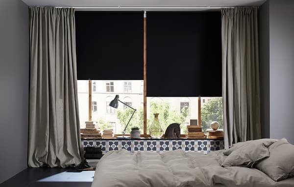 Camera da letto con tende a rullo oscuranti nere e uno strato di tende spesse grigie - IKEA