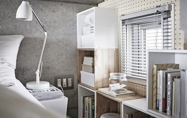 Camera da letto in grigio e bianco con contenitori in legno.