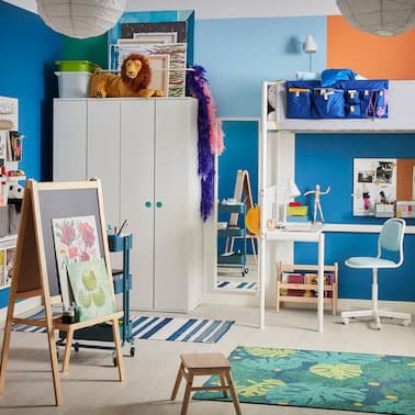 Cameretta colorata con letto a soppalco bianco, cavalletto da pittore, tappeto con disegno di foglie e sedia da scrivania per bambini – IKEA