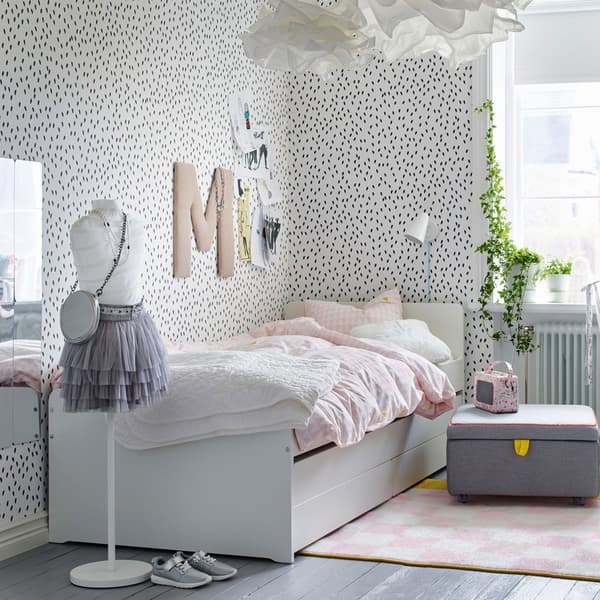 Cameretta con pareti bianche punteggiate di nero e letto bianco con biancheria rosa pallido – IKEA