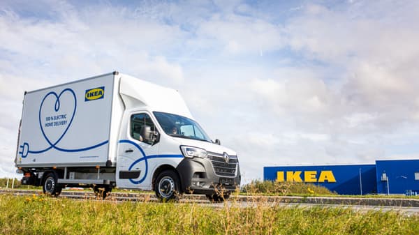 Camió elèctric d’IKEA blanc i blau amb una botiga de fons.