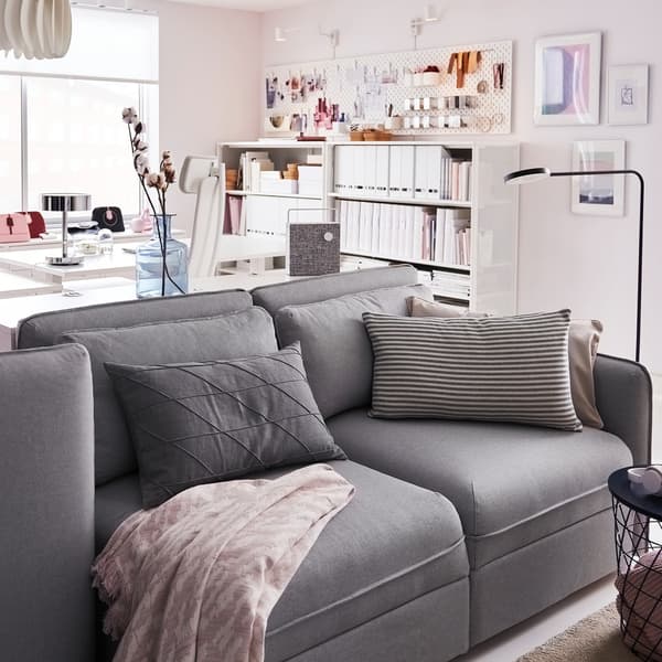 Canapé 3 places IKEA VALLENTUNA gris clair devant des bureaux blancs.