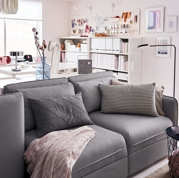 Canapé 3 places IKEA VALLENTUNA gris clair devant un bureau à domicile.