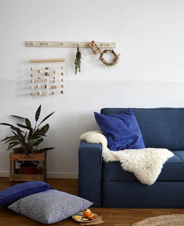 Canapé bleu décoré d’une peau de mouton et de coussins bleus.