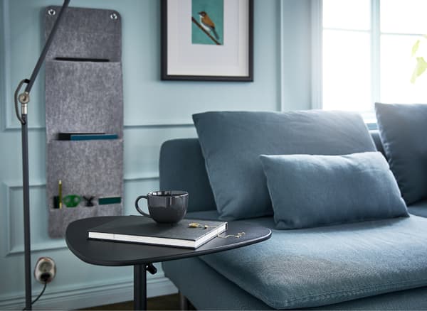 Canapé, lampadaire, support réglable pour portable et organisateur à suspendre pour accessoires font partie intégrante de ce bureau-canapé
