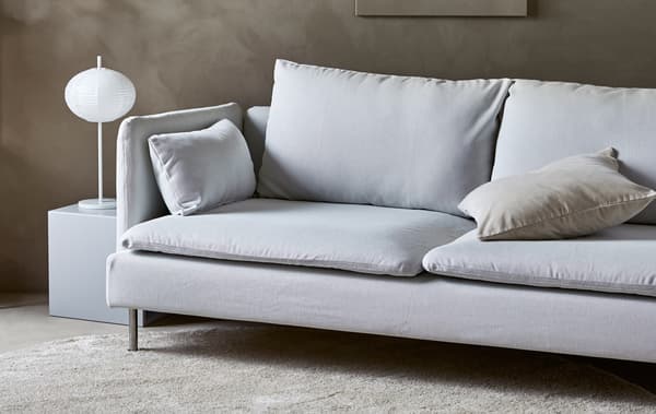 Canapé moderne dans un séjour de style minimaliste chaleureux, couleur sable.