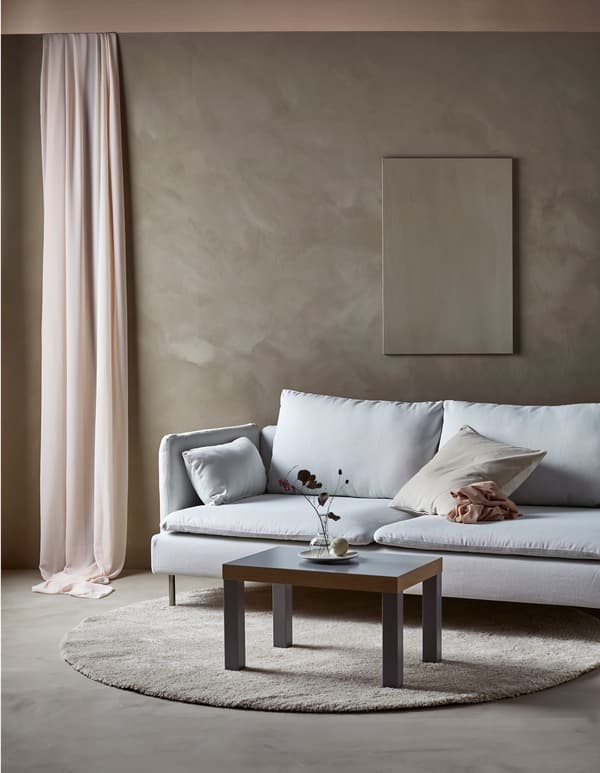 Canapé moderne dans un séjour minimaliste avec une seule œuvre d’art au mur et table basse simple