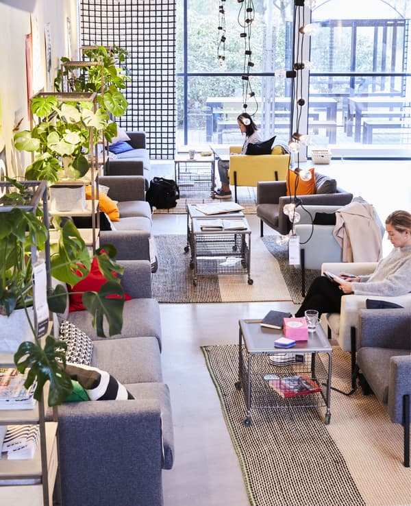 Canapés, fauteuils et tables basses dans un espace de travail décloisonné.