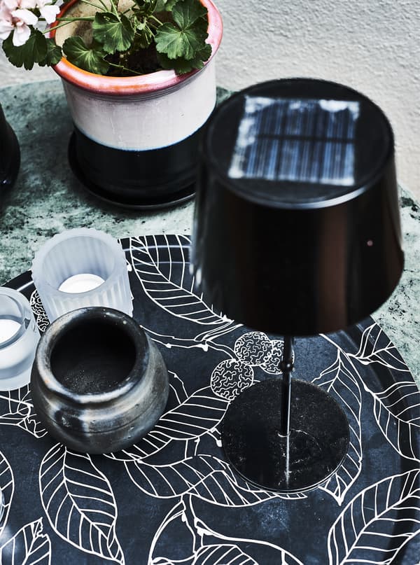 Candles and a solar-powered lamp on a tray.