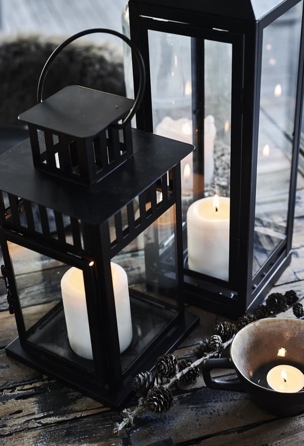 Candles in large lanterns on the table.