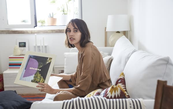 Carolina seduta sul divano bianco del suo soggiorno - IKEA