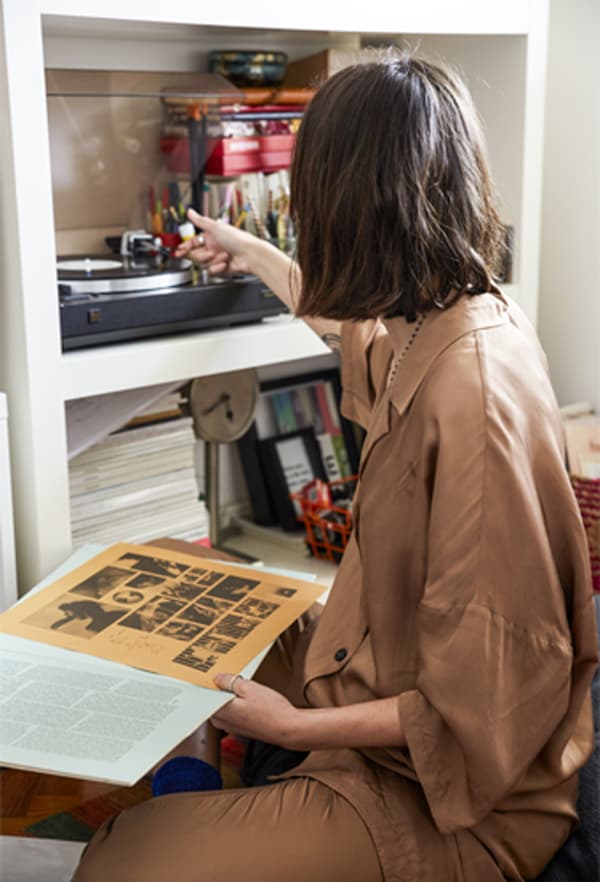 Carolina sitting on the floor playing records.