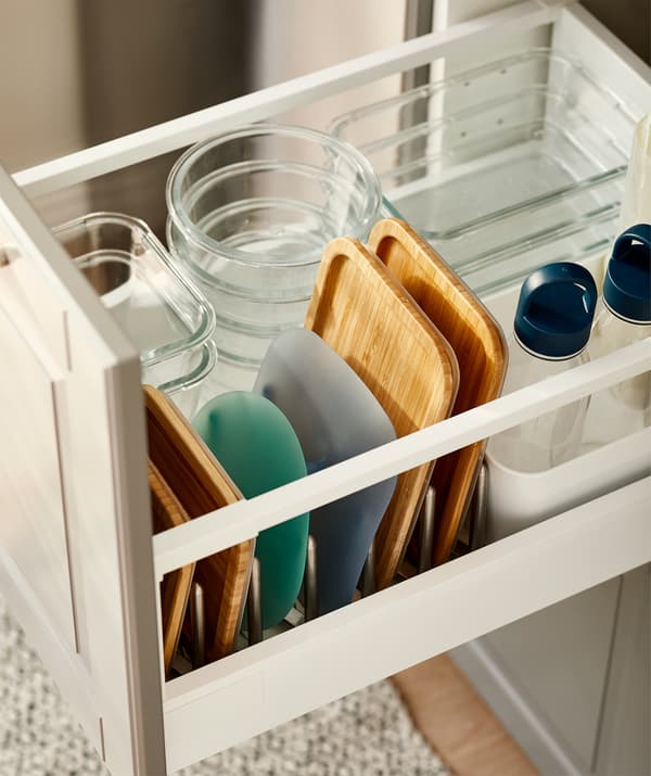 Cassetto della cucina con portavivande in vetro di misure diverse, con i rispettivi coperchi organizzati in un portacoperchi - IKEA