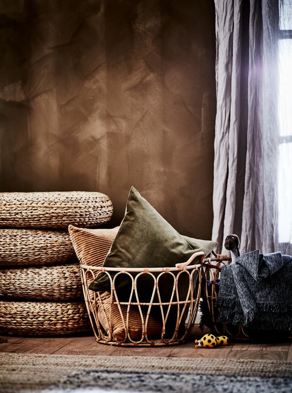 Časť miestnosti v hnedých zemitých odtieňoch s ratanovými kreslami SNIDAD s textíliami, pletenými podnožkami a kobercami z prírodných materiálov. 