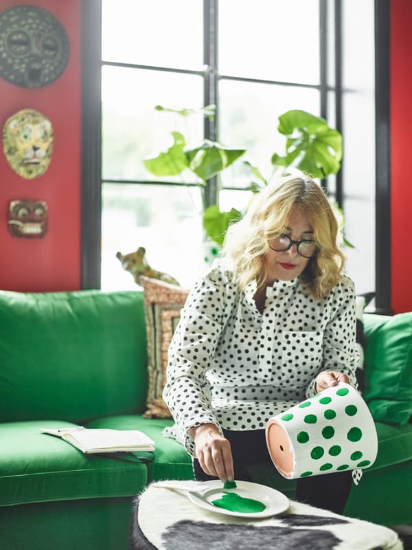 Cecilia Höglund paints a pot with polka dots.