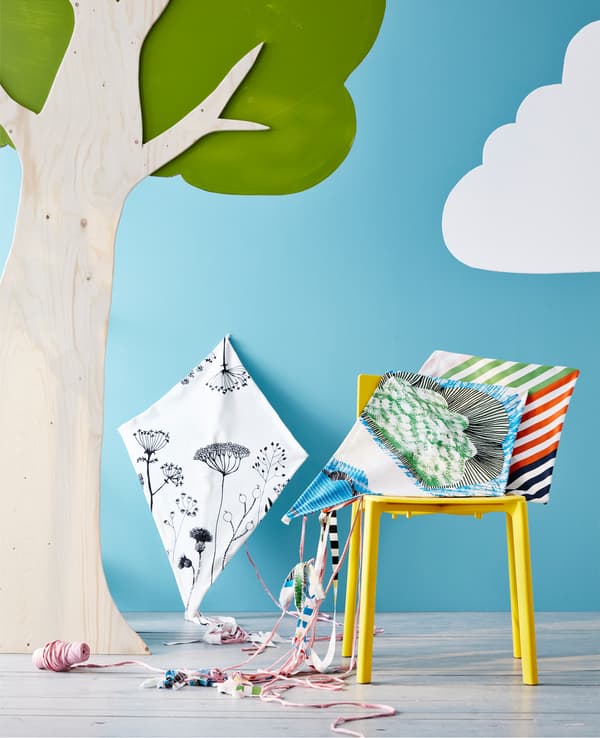 Cerf-volant bricolé posé sur une chaise, à côté d’un arbre.