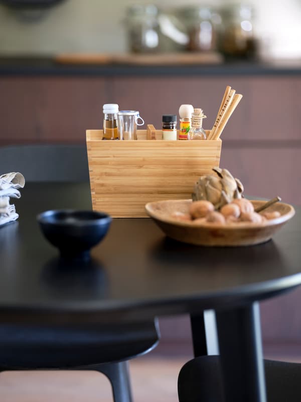 Černý stůl a černomodré židle BALTSAR, na stole stojí bambusová krabice s rukojetí VARIERA.