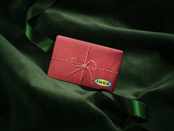 Červená dárková karta IKEA se vzorem dárku na zelené, sametové látce.