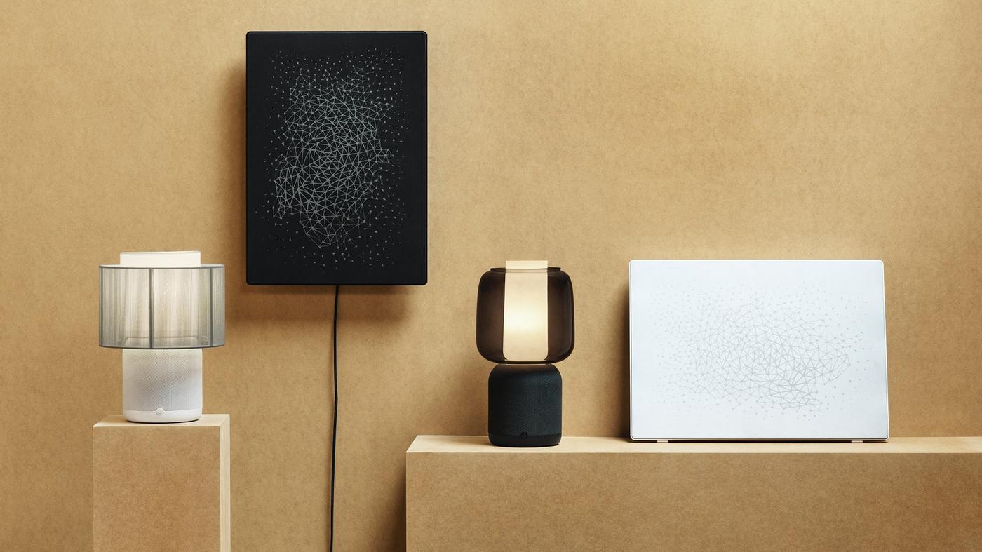 Četiri moderne lampe različitih oblika i boja postavljene na drvene blokove ispred smeđe pozadine