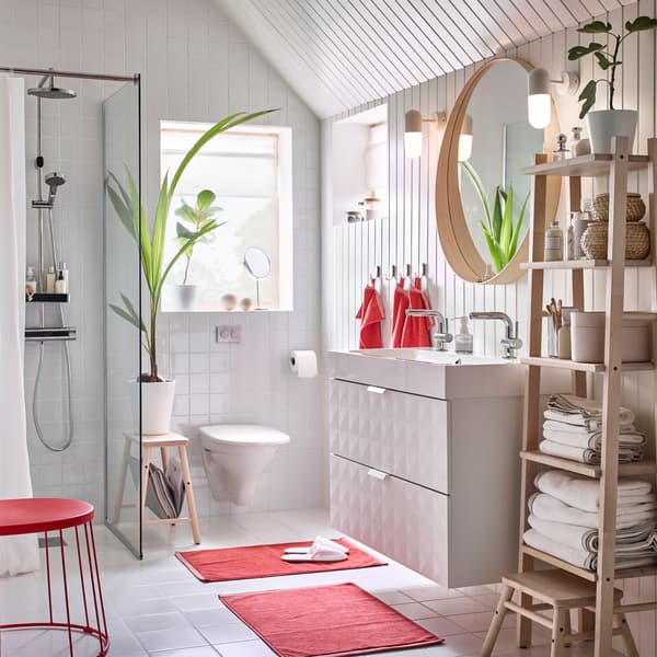 Cette salle de bain IKEA qui marie le blanc et le rouge est dotée d’un double lavabo GODMORGON, ce qui permet d’utiliser la salle de bain à plusieurs en même temps.