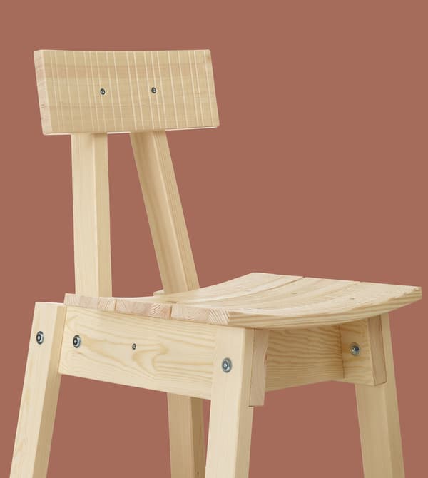 Chaise en bois clair sur fond terre cuite.