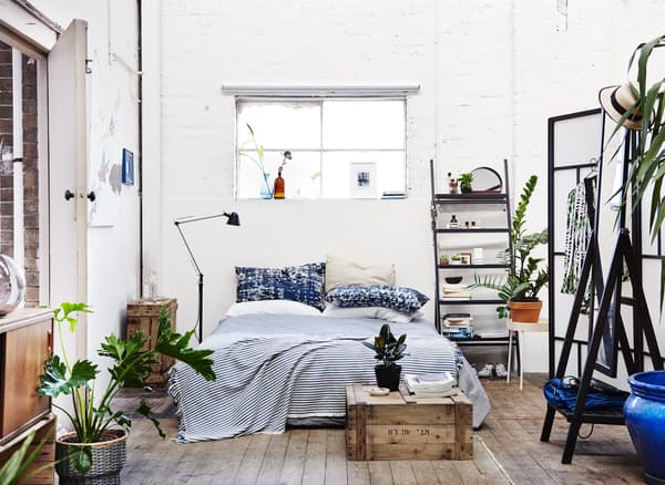 Chambre à coucher blanche avec détails en bois noirs et naturels.
