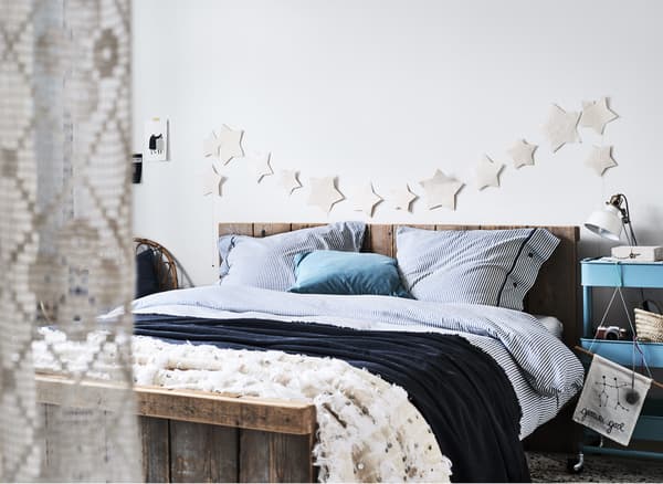 Chambre à coucher blanche avec linge de lit à rayures bleues.