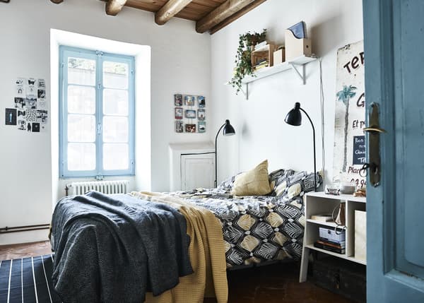 Chambre à coucher en bleu et blanc, avec accents jaunes.