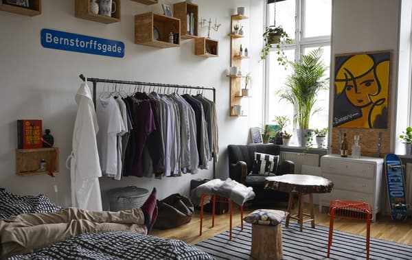 Chambre avec lit, table basse et rangements ouverts.