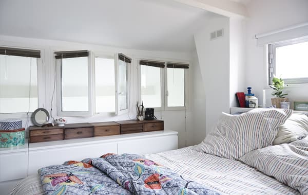 Chambre avec murs blancs et rangements intelligents