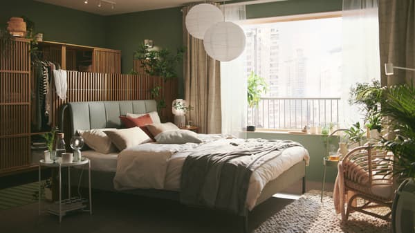 Chambre avec textile de lit vert sauje et luminaire boules blancs