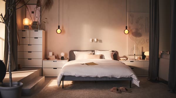 Chambre avec un lit central SLATTUM Cadre de lit matelassé, Knisa gris clair et des rangements NORDLI