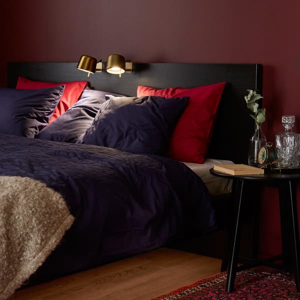 Chambre cosy avec lampes de lecture fixées sur la tête de lit.