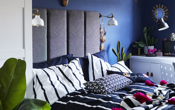 Chambre d’enfant avec murs bleus et literie monochrome.